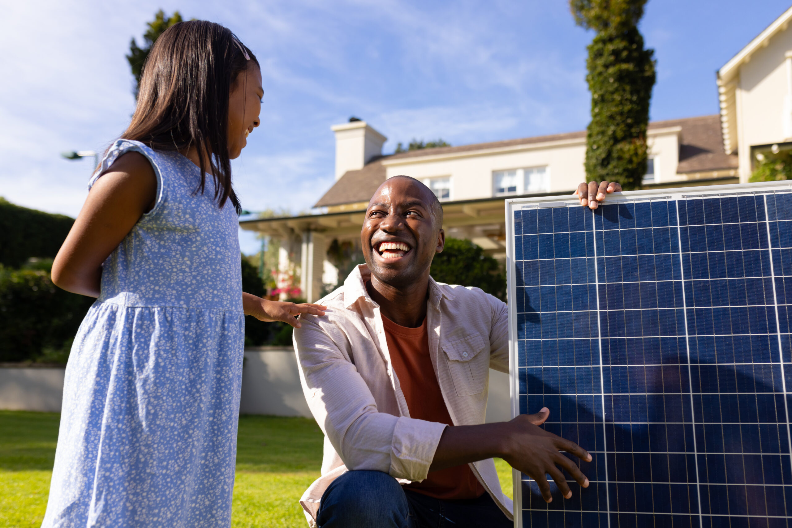 outdoors diverse father daughter smiling each other holding solar panel scaled